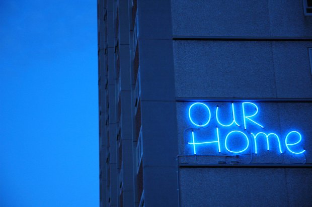 Our Home neon sign attached to an Atherton Gardens building